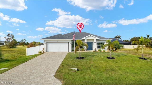 ranch-style house featuring decorative driveway, an attached garage, fence, and a front lawn