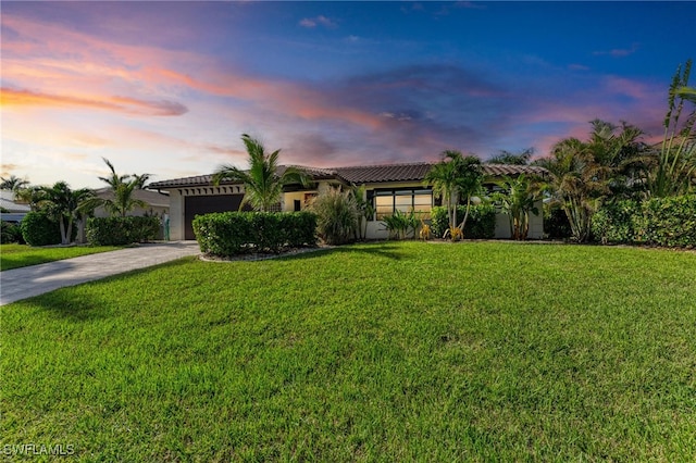 mediterranean / spanish-style house with a lawn and a garage