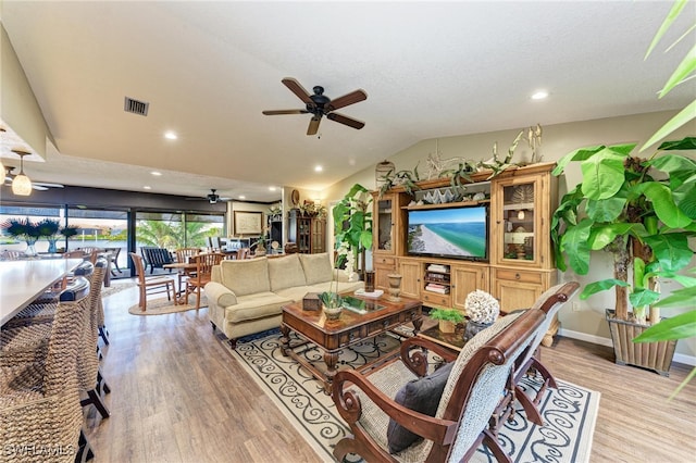 living room with vaulted ceiling, light hardwood / wood-style flooring, and ceiling fan