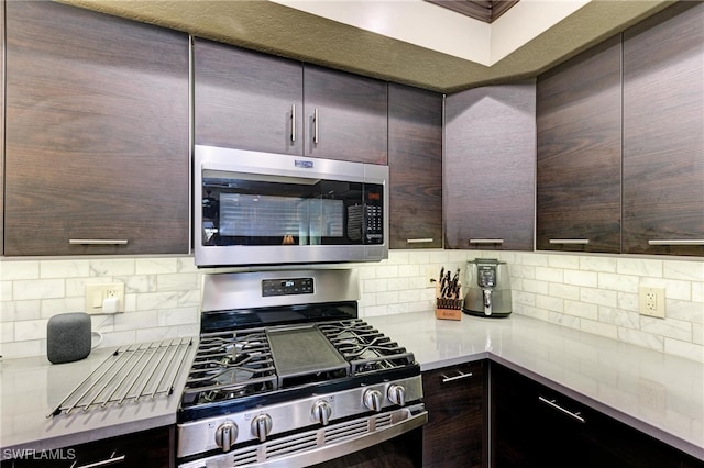 kitchen with tasteful backsplash, stainless steel appliances, and dark brown cabinets