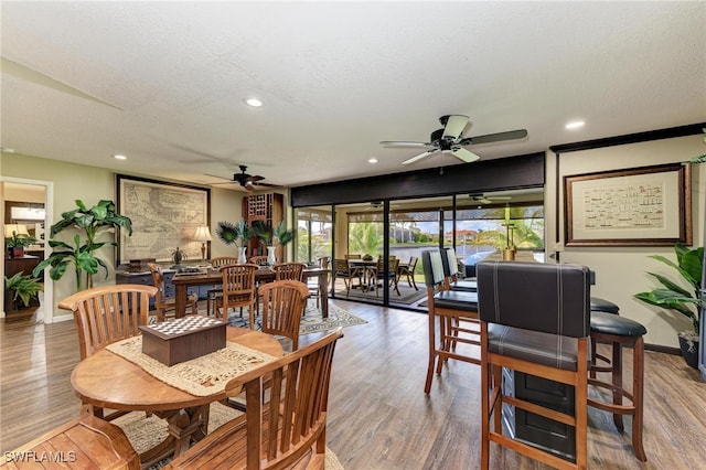 dining space with a textured ceiling, hardwood / wood-style flooring, and ceiling fan