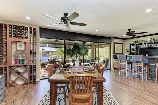 dining area with ceiling fan, wood-type flooring, and a textured ceiling