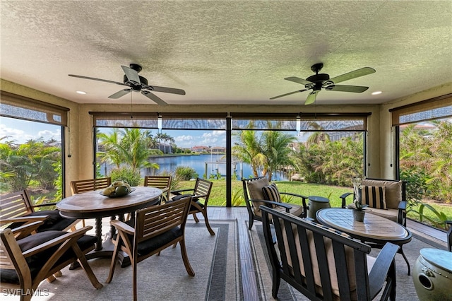 sunroom with a water view and ceiling fan