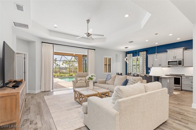 living room featuring ceiling fan and light wood-type flooring