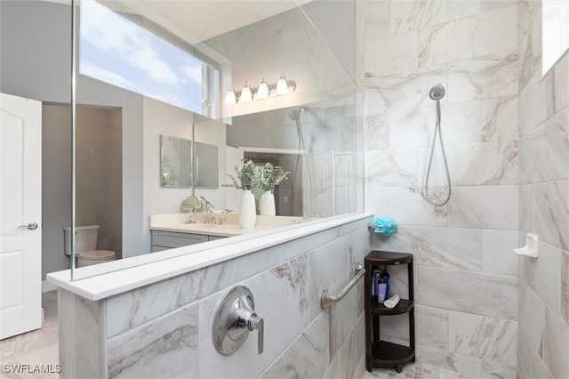 bathroom featuring vanity, toilet, and tiled shower