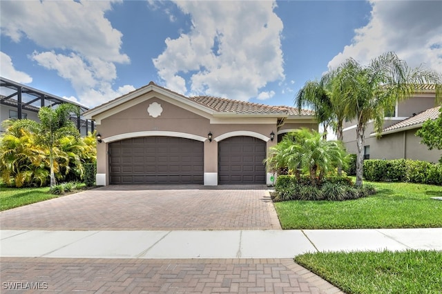 mediterranean / spanish house with a front lawn and a garage