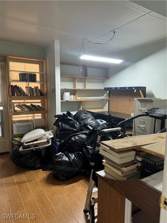 miscellaneous room with wood-type flooring and an AC wall unit