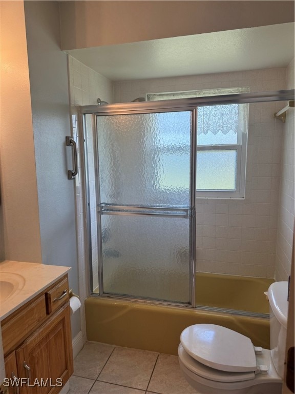 full bathroom with toilet, vanity, tile patterned floors, and enclosed tub / shower combo