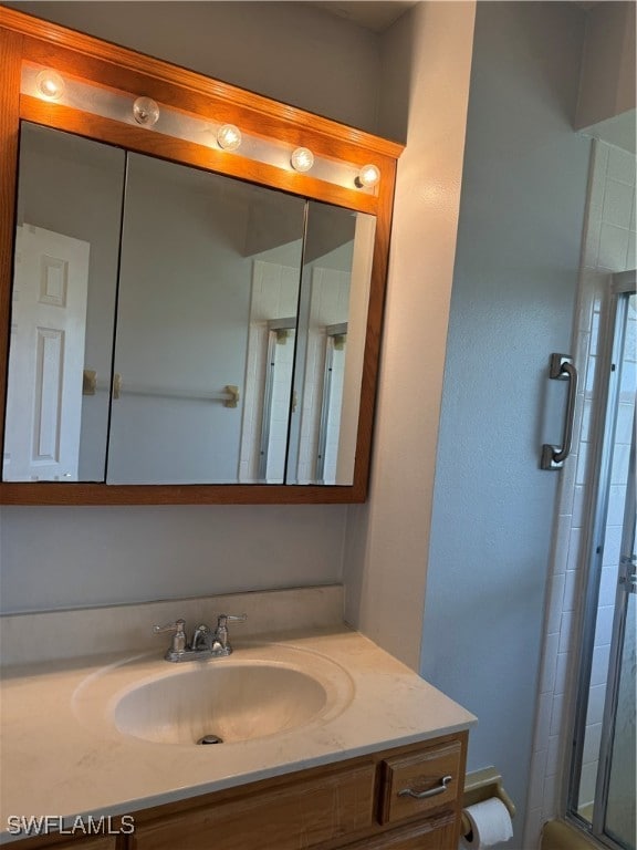 bathroom with vanity and a shower with shower door