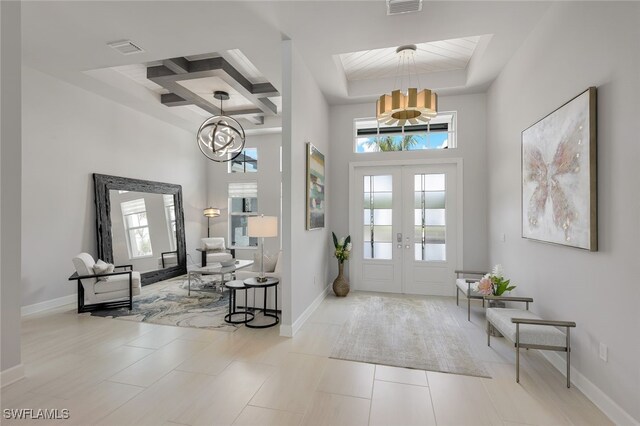 tiled foyer with a towering ceiling, plenty of natural light, french doors, and coffered ceiling