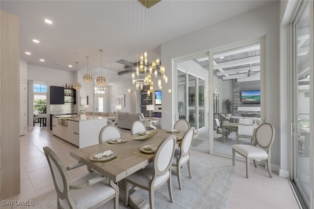 tiled dining area with ceiling fan with notable chandelier