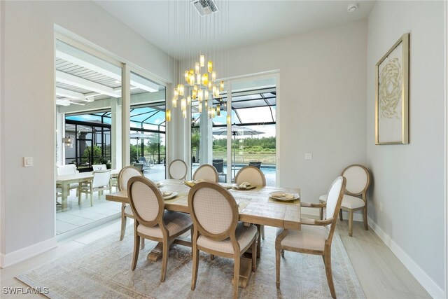 dining area featuring light hardwood / wood-style floors and a chandelier