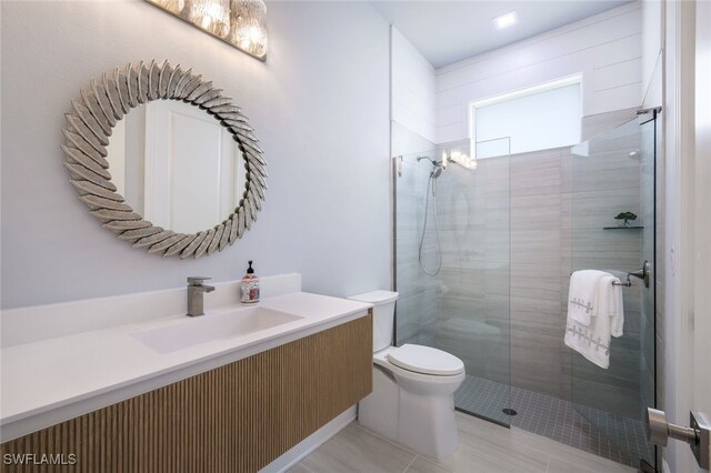 bathroom with walk in shower, vanity, and toilet