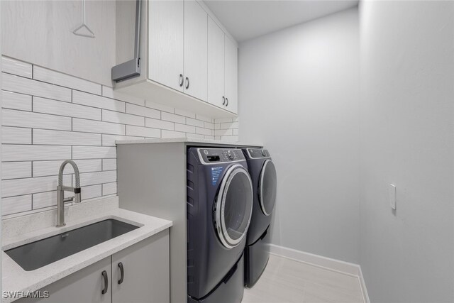 laundry room with cabinets, sink, and washing machine and clothes dryer