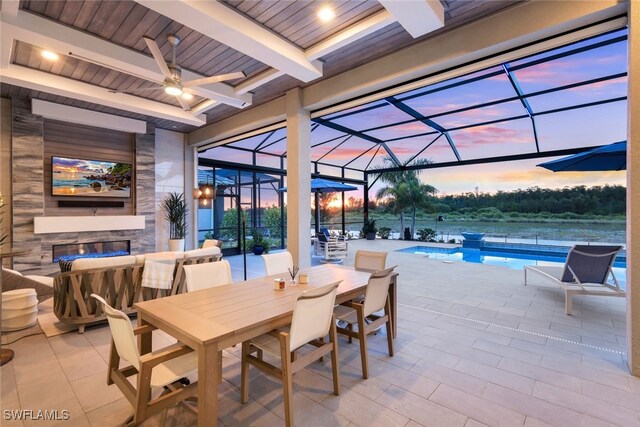 patio terrace at dusk with ceiling fan and glass enclosure