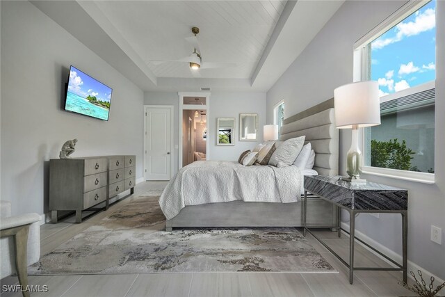 bedroom with ceiling fan and a raised ceiling