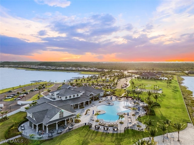 aerial view at dusk featuring a water view