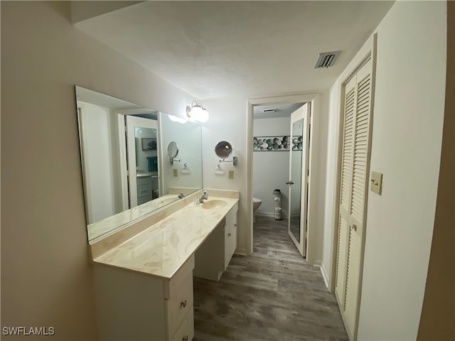 bathroom with vanity, hardwood / wood-style flooring, and toilet