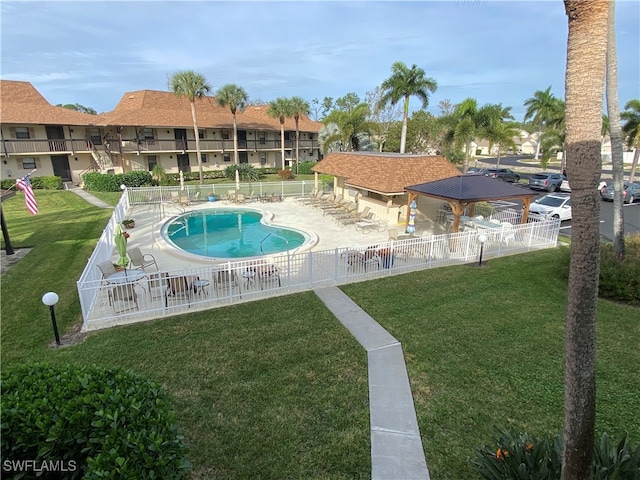 view of pool with a patio and a lawn