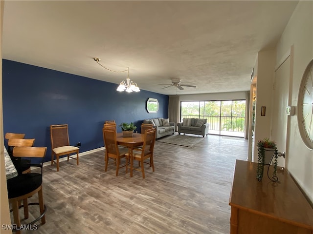 dining room featuring hardwood / wood-style flooring and ceiling fan with notable chandelier