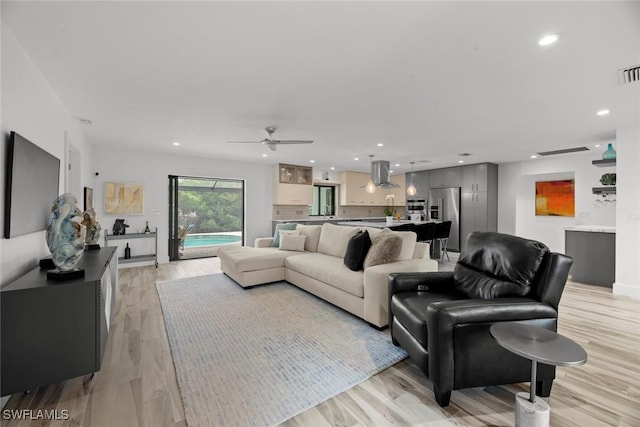 living room featuring ceiling fan and light wood-type flooring