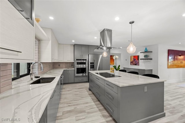 kitchen featuring gray cabinets, sink, and hanging light fixtures