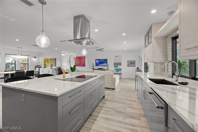 kitchen featuring gray cabinets, a kitchen island, island range hood, stainless steel dishwasher, and black electric stovetop