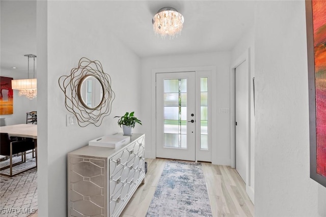 entryway with a chandelier and light hardwood / wood-style floors