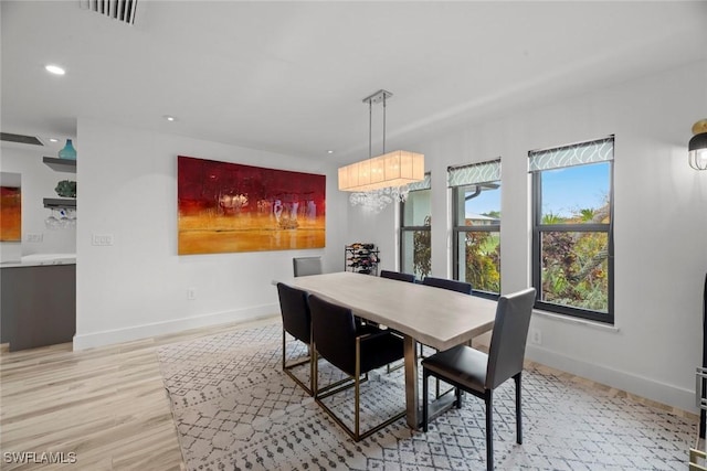 dining area featuring plenty of natural light, a chandelier, and light hardwood / wood-style flooring