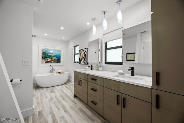 bathroom with a tub to relax in, hardwood / wood-style floors, and vanity