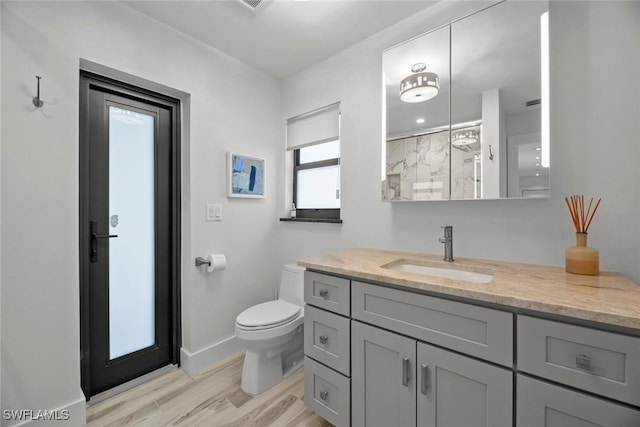 bathroom with walk in shower, vanity, toilet, and hardwood / wood-style floors