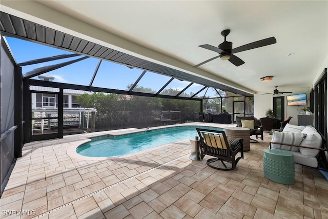 view of swimming pool with an outdoor living space, a lanai, ceiling fan, and a patio area