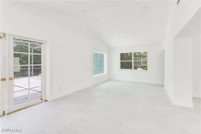 tiled spare room with high vaulted ceiling and plenty of natural light