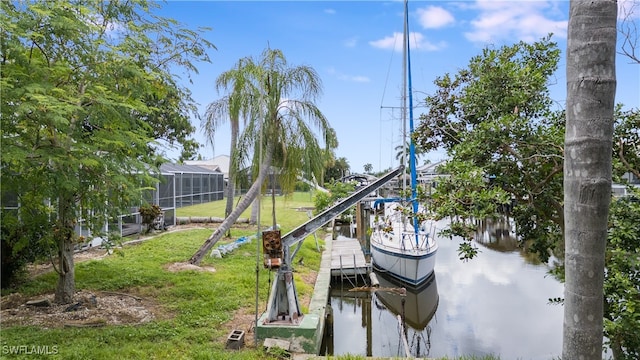 dock area featuring a lanai, a lawn, and a water view