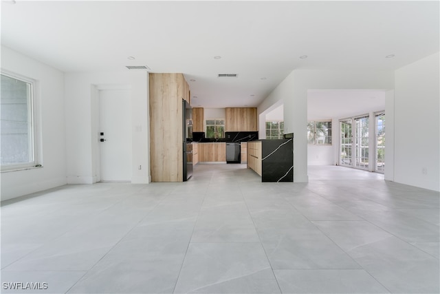 kitchen with light brown cabinets, stainless steel appliances, and light tile patterned floors