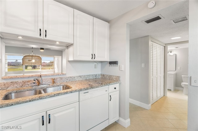 1660 Pine Valley Dr Unit 203, Fort Myers, FL 33907 - kitchen with white dishwasher, a sink, white cabinetry, baseboards, and light stone counters