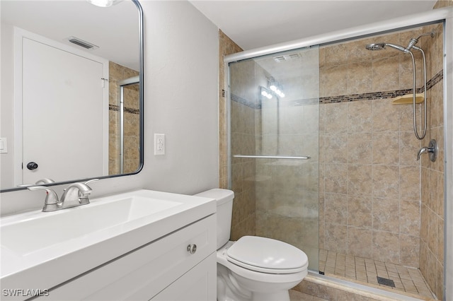 bathroom featuring toilet, vanity, and walk in shower