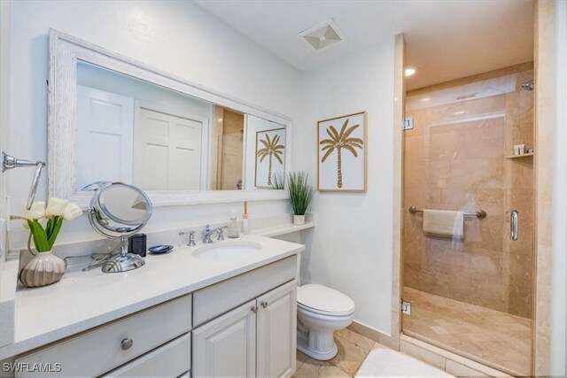 bathroom with tile patterned floors, vanity, toilet, and a shower with door