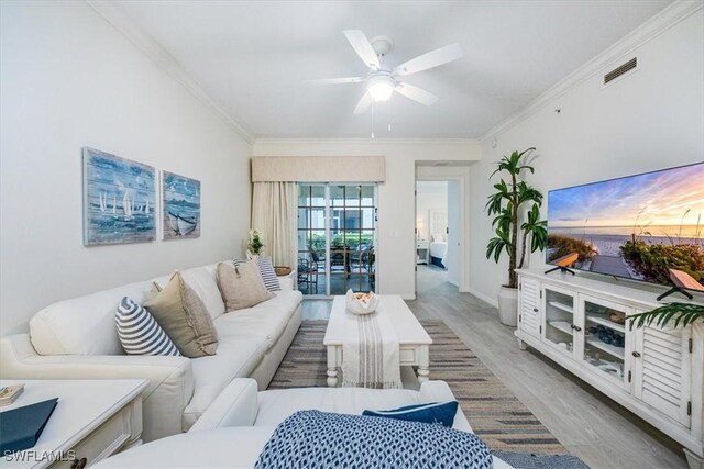 living room with light wood-type flooring, ceiling fan, and crown molding