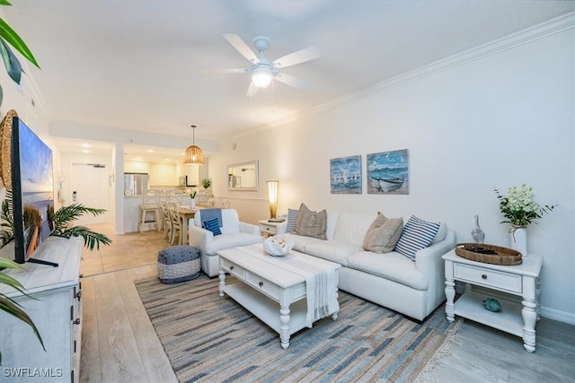 living room featuring light wood-type flooring, ceiling fan, and crown molding