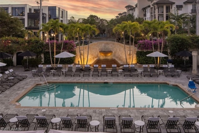 pool at dusk featuring a patio