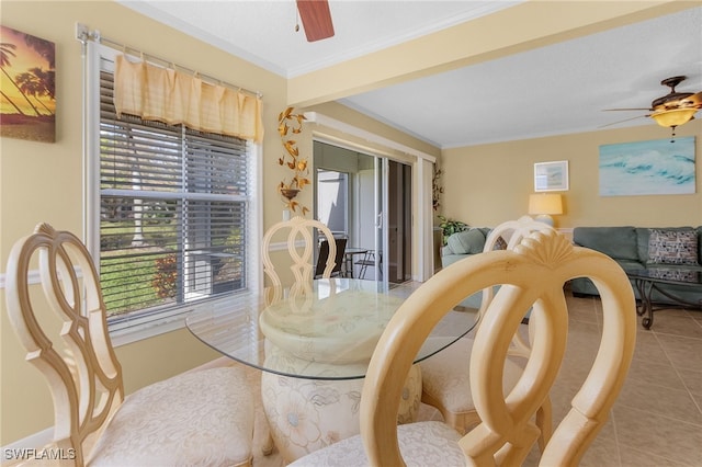 tiled dining space with ceiling fan and crown molding