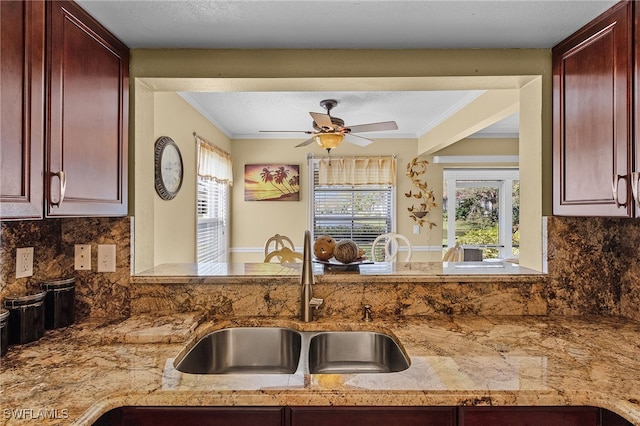 kitchen with ceiling fan, sink, backsplash, and ornamental molding