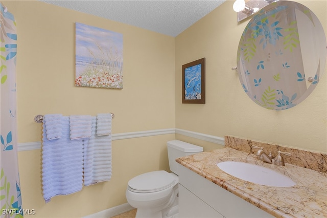 bathroom featuring vanity, a textured ceiling, and toilet