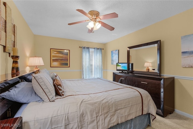 bedroom with a textured ceiling, light carpet, and ceiling fan