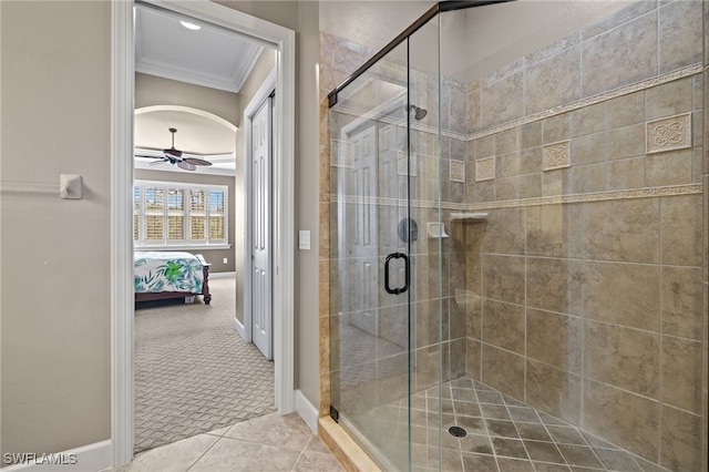 bathroom with crown molding, tile patterned floors, ceiling fan, and a shower with shower door