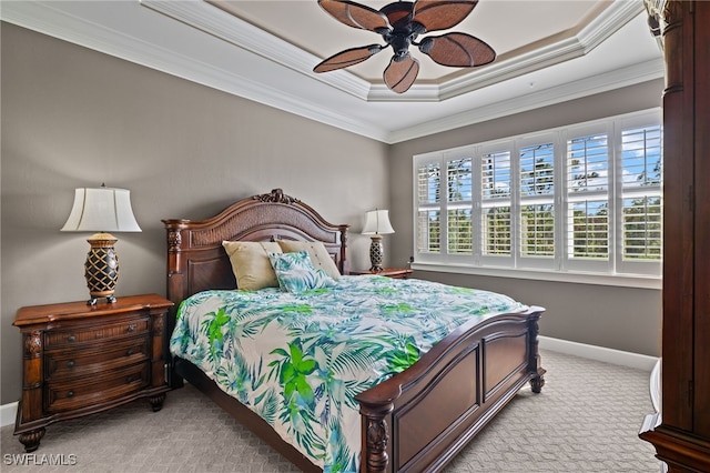 bedroom with ceiling fan, ornamental molding, a raised ceiling, and light colored carpet