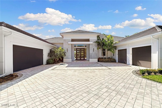 607 Myrtle Rd, Naples, FL 34108 - view of front of house featuring decorative driveway, a tiled roof, stucco siding, a garage, and french doors