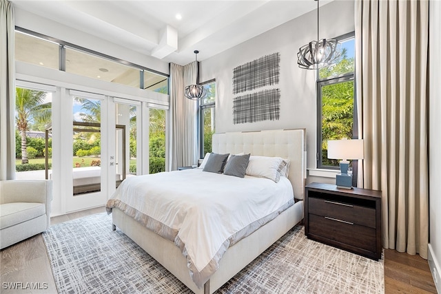 bedroom featuring a chandelier, access to outside, and light hardwood / wood-style floors