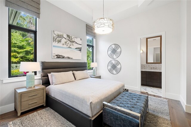 bedroom with ensuite bathroom and wood-type flooring